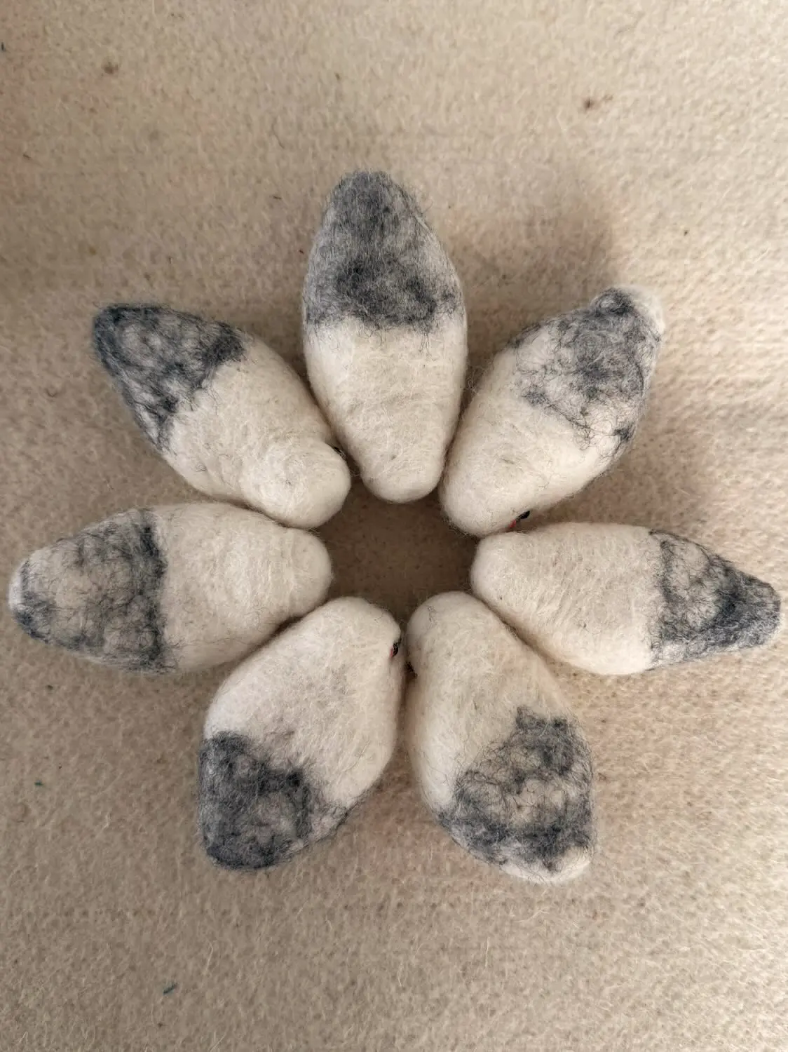 Loose wool in the maker's hands before an AWEBO bird is formed.